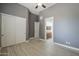 Bedroom boasts a closet and en-suite bathroom, wood-style flooring, ceiling fan at 10033 W Jj Ranch Rd, Peoria, AZ 85383
