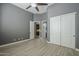Gray bedroom with ceiling fan and tile flooring showcases doorways and a closet at 10033 W Jj Ranch Rd, Peoria, AZ 85383
