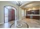 Inviting home foyer featuring an arched entry, detailed tile flooring, and wet bar at 10033 W Jj Ranch Rd, Peoria, AZ 85383