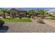 Beautiful single-story home with well-maintained landscaping, desert rock, and lush palm trees at 10033 W Jj Ranch Rd, Peoria, AZ 85383