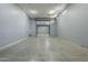 Large garage with roll up door, concrete floor, and ample lighting for a functional workspace at 10033 W Jj Ranch Rd, Peoria, AZ 85383