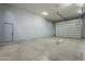 Garage interior featuring a roll-up door, concrete floor, and side entry door at 10033 W Jj Ranch Rd, Peoria, AZ 85383