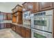 Kitchen with stainless steel oven and microwave along with granite countertops and custom wood cabinets at 10033 W Jj Ranch Rd, Peoria, AZ 85383