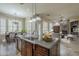 Open-concept kitchen with granite counters, stainless appliances, and adjacent dining and living areas at 10033 W Jj Ranch Rd, Peoria, AZ 85383