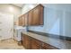 A well-lit laundry room features cabinetry, granite countertops, washer, and dryer at 10033 W Jj Ranch Rd, Peoria, AZ 85383