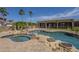 Backyard pool and jacuzzi area accented with stone and tropical landscaping at 10033 W Jj Ranch Rd, Peoria, AZ 85383