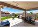 Covered back patio with outdoor kitchen, dining area, and view of the backyard at 11755 W Patrick Ln, Sun City, AZ 85373