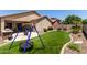 Backyard featuring a custom playset, turf, and desert landscaping at 11755 W Patrick Ln, Sun City, AZ 85373