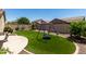 Green backyard with turf, a custom playset and mature landscaping for added privacy at 11755 W Patrick Ln, Sun City, AZ 85373