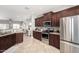 Modern kitchen featuring stainless steel appliances, dark cabinetry, and an open layout perfect for entertaining at 11755 W Patrick Ln, Sun City, AZ 85373