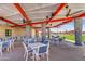 Outdoor patio area with modern seating, dining tables, and a covered pergola structure at 12039 E Primrose Ln, Florence, AZ 85132