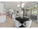 An open dining area with modern lighting, seamlessly connected to an outdoor patio and pool at 13186 W Via Dona Rd, Peoria, AZ 85383