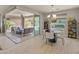 An open dining area with modern lighting, seamlessly connected to an outdoor patio and pool at 13186 W Via Dona Rd, Peoria, AZ 85383