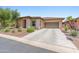 Charming exterior of the home with desert landscaping, concrete driveway and stone facade at 13186 W Via Dona Rd, Peoria, AZ 85383