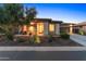 Beautiful home exterior at dusk with stone accents, desert landscaping, and long driveway at 13186 W Via Dona Rd, Peoria, AZ 85383