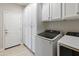 Well-organized laundry room featuring new appliances, white cabinets, and convenient storage at 13186 W Via Dona Rd, Peoria, AZ 85383