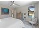 Bright main bedroom featuring a ceiling fan, modern decor, and serene views of the backyard swimming pool at 13186 W Via Dona Rd, Peoria, AZ 85383
