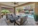 Inviting outdoor living space with a covered patio, comfortable seating, and a serene pool area at 13186 W Via Dona Rd, Peoria, AZ 85383
