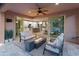 Covered patio boasts comfortable seating, a modern fire pit, and sliding glass doors to the open-concept kitchen at 13186 W Via Dona Rd, Peoria, AZ 85383