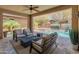 A covered patio with stylish outdoor seating overlooks a pool and spa at 13186 W Via Dona Rd, Peoria, AZ 85383