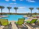 Relaxing pool area with palm trees, lounge chairs, and clear blue skies providing a resort-style experience at 13186 W Via Dona Rd, Peoria, AZ 85383