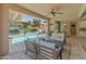 Covered outdoor living area featuring a firepit, multiple seating areas, and refreshing backyard pool at 13186 W Via Dona Rd, Peoria, AZ 85383
