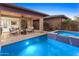 Resort-style backyard with travertine decking, pool, spa, covered patio, and desert landscaping, perfect for entertaining at 13186 W Via Dona Rd, Peoria, AZ 85383