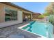 Lush backyard with sparkling pool and tranquil waterfall feature, perfect for relaxing and enjoying outdoor living at 13186 W Via Dona Rd, Peoria, AZ 85383