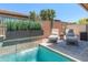Backyard pool area with comfortable lounge chairs and a tranquil waterfall feature, offering a relaxing retreat at 13186 W Via Dona Rd, Peoria, AZ 85383