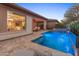 Beautiful pool features a tanning ledge, travertine decking, and a calming waterfall feature for an outdoor escape at 13186 W Via Dona Rd, Peoria, AZ 85383
