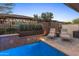 Inviting pool area with a waterfall feature, mature landscaping, travertine deck, and seating area for outdoor enjoyment at 13186 W Via Dona Rd, Peoria, AZ 85383