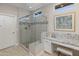 Modern walk-in shower featuring decorative tile and a glass enclosure, complemented by a granite countertop vanity at 13186 W Via Dona Rd, Peoria, AZ 85383