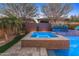 Inviting spa area with travertine decking, a waterfall feature, privacy landscaping, and accent lighting for ambiance at 13186 W Via Dona Rd, Peoria, AZ 85383