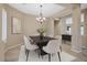 Formal dining room with elegant chandelier, stylish furniture, and neutral color palette at 13945 E Gail Rd, Scottsdale, AZ 85259