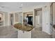 Kitchen island with granite countertop, black refrigerator, and light wood cabinetry at 13945 E Gail Rd, Scottsdale, AZ 85259