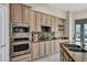 Kitchen with stainless steel appliances, granite backsplash, and light wood cabinets at 13945 E Gail Rd, Scottsdale, AZ 85259