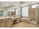 Well-lit bathroom with dual sinks, a soaking tub, and a separate shower at 13945 E Gail Rd, Scottsdale, AZ 85259
