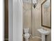 Elegant powder room featuring a pedestal sink and decorative mirror at 13945 E Gail Rd, Scottsdale, AZ 85259