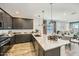 Open-concept kitchen with a spacious island, dark cabinetry, and a seamless flow to the dining and living area at 1415 W J Waltz Way, Apache Junction, AZ 85120