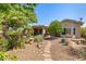 Landscaped backyard featuring a covered patio and lush greenery, perfect for outdoor enjoyment at 14819 W Lupine Ln, Surprise, AZ 85374