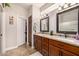 Elegant bathroom featuring double sinks with granite countertops, wood cabinetry, and ample storage, perfect for a luxurious experience at 14819 W Lupine Ln, Surprise, AZ 85374