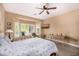Sun-drenched bedroom featuring a bay window with plantation shutters, a ceiling fan, and neutral walls offering a calming space at 14819 W Lupine Ln, Surprise, AZ 85374