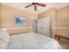 Neutral bedroom features a ceiling fan, closet, adjacent bathroom, and an accent bench at 14819 W Lupine Ln, Surprise, AZ 85374
