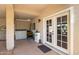 Covered patio leading to French doors and storage with a landscaped view and a privacy wall at 14819 W Lupine Ln, Surprise, AZ 85374
