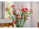 Close-up of a vase filled with red and white flowers adding color to the room at 14819 W Lupine Ln, Surprise, AZ 85374