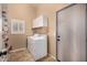 Laundry room with washer and dryer, storage shelves, a window, and access door at 14819 W Lupine Ln, Surprise, AZ 85374