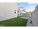View of the home's backyard area featuring artificial grass and block wall fencing at 15718 W Polk St, Goodyear, AZ 85338