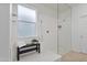 Modern bathroom featuring a glass-enclosed shower, bench, and neutral tones at 15718 W Polk St, Goodyear, AZ 85338