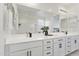 Bright bathroom featuring double sinks, white cabinets, and contemporary fixtures at 15718 W Polk St, Goodyear, AZ 85338