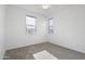 Bright, carpeted bedroom with two windows and neutral decor at 15718 W Polk St, Goodyear, AZ 85338